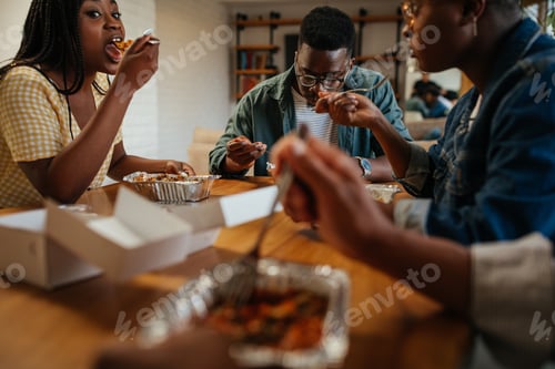 Preview: Young happy friends having fun during lunchtime at home