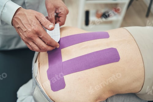Preview: Experienced physiatrist using kinesiology taping method for low back pain