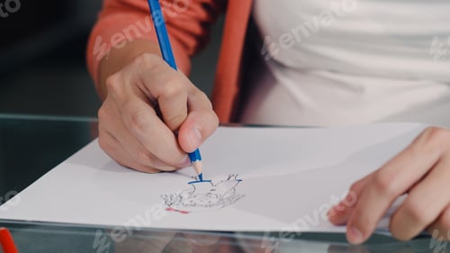 Preview: Young Asian Pregnant woman drawing baby in belly and family in notebook.