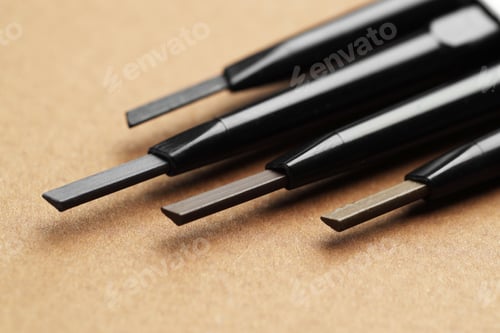Preview: Automatic eyebrow pencils on brown background, macro view