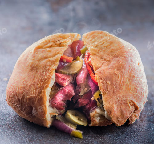 Preview: Close-up of a meat and vegetable Muffuletta sandwich sliced through the middle