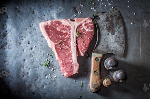 Preview: Red and raw t-bone steak on old metal table