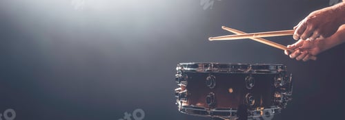 Preview: A man plays a snare drum on a dark background, copy space.