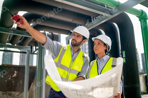Preview: Professional engineer man use walkie-talkie to point and explain to his coworker woman