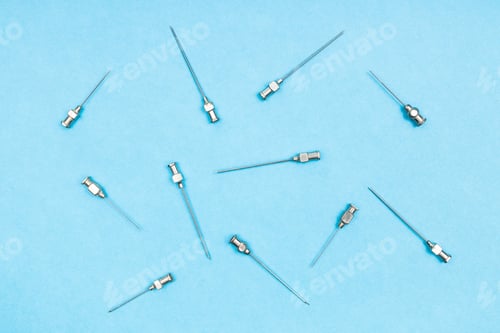Preview: top view of vintage hypodermic needles on blue