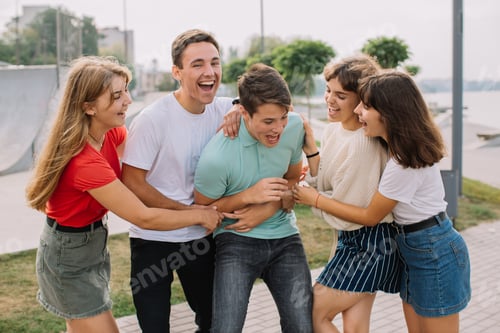 Vista previa: Summer holidays and teenage concept - group of smiling teenagers hanging out outside.