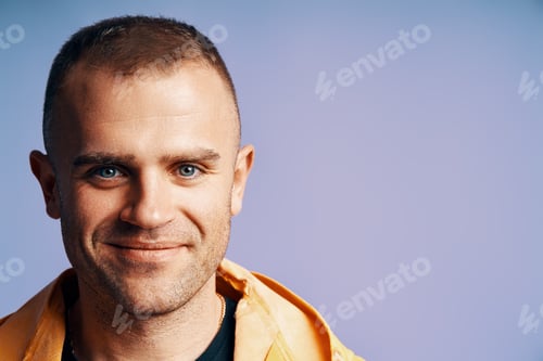 Preview: Close-up portrait of handsome young man looking to camera over soft blue background