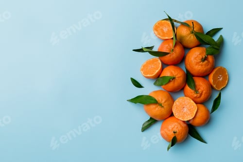 Preview: Many fresh ripe mandarin with green leaves on colored background, top view, space for text