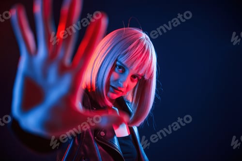 Preview: Hand in front of her. Woman with white hair is in studio with neon colors