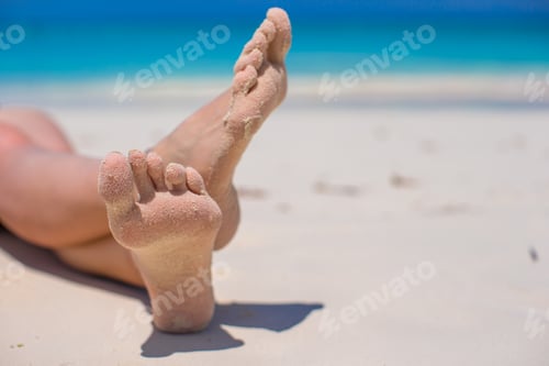 Preview: Close up of female feet on white sandy beach