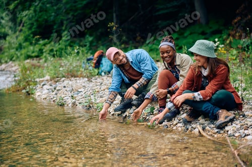Preview: Group of happy of hikers having fun by clean mountain creek.