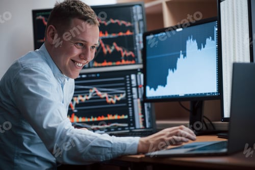 Preview: Man working online in the office with multiple computer screens in index charts
