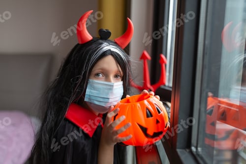 Preview: Portrait of cute Little Girl in costume of evil at home. Happy Halloween during coronavirus