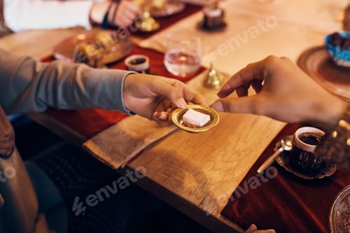 Preview: Close-up of Middle Eastern people having rahat lokum for dessert while drinking coffee at home.