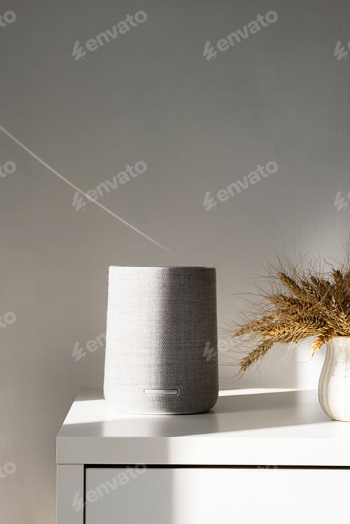 Preview: Modern gray speaker on table with soft shadows and light.