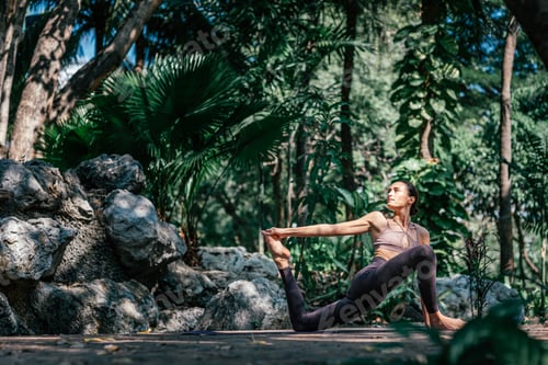 Preview: Focused Woman Practicing Yoga Outdoors in a Lush Forest