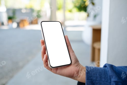Preview: Mockup image of a woman holding and using mobile phone in the outdoors