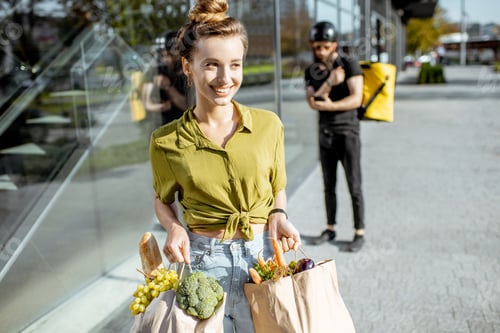 Preview: Woman with fresh products received from a courier