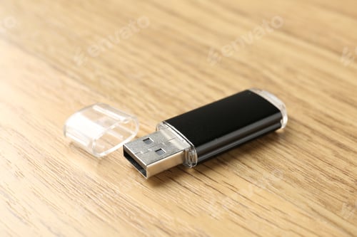Preview: One flash drive on wooden background, closeup. Space for text