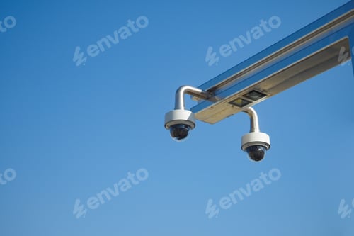 Preview: Surveillance Cameras Positioned Against a Clear Blue Sky on a Bright Day of Activities