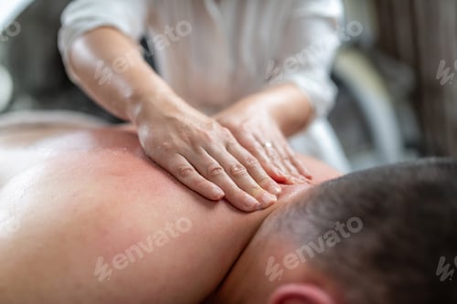 Preview: Therapist exfoliates the back using circular motions, focusing on dry patches.