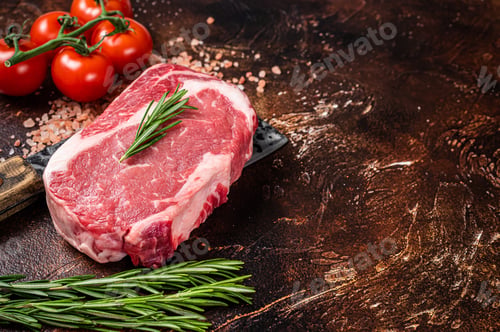 Preview: Uncooked raw Rib eye Steak, ribeye beef meat on butcher cleaver with herbs.
