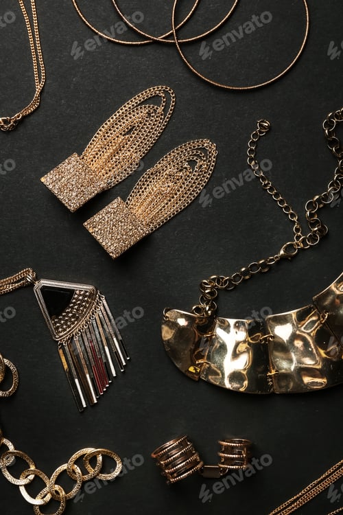 Preview: Set of gold jewelry on black background, flat lay