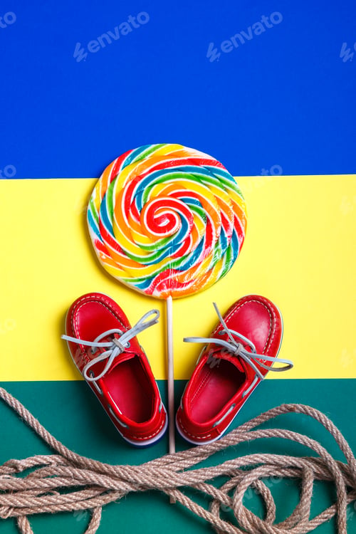 Preview: Small red boat shoes near big multi-colored lollipop