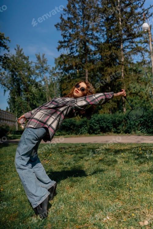 Preview: outdoors in a park with trees against the backdrop of surrender a young brunette girl hits serve