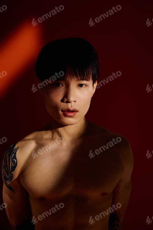 Preview: Stylish young asian man posing confidently against a vibrant backdrop in a modern setting