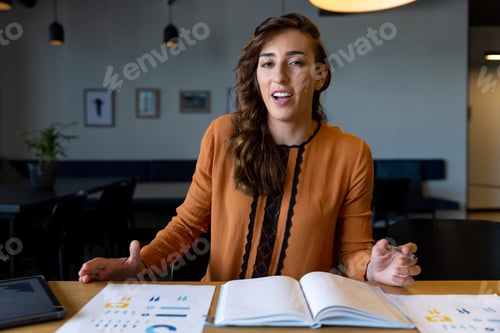 Preview: Happy caucasian casual businesswoman talking and gesturing during video call at desk in office
