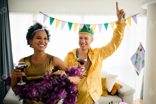Preview: Happy multiracial friends dancing and having fun at the party during Mardi Gras celebration.