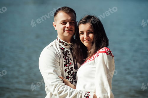 Preview: beautiful brunette bride and elegant stylish groom with true feelings near a sunny lake