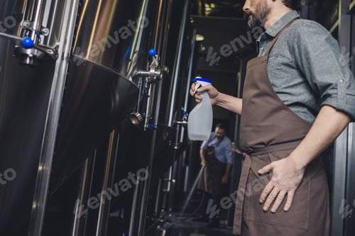 Preview: Male brewery worker spraying brewery tank