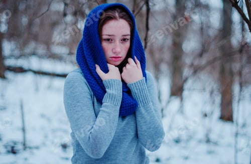 Preview: Portrait of young red hair girl with freckles wearing at blue knitted wool scarf in winter day.