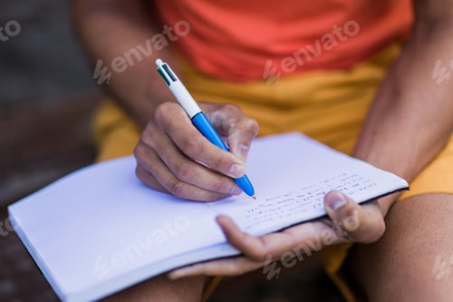 Preview: Indian mid adult south asian handsome man write outdoor on travel diary in Asturias, Spain