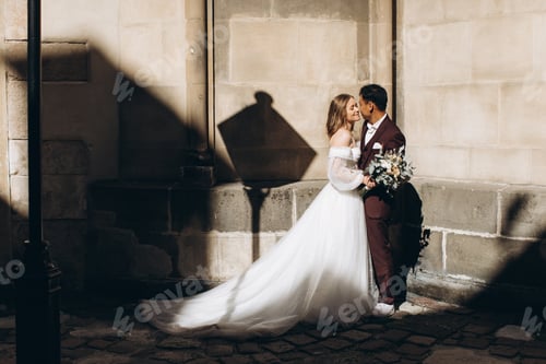 Preview: An international wedding couple, a European bride and an Asian groom walk around the city together.