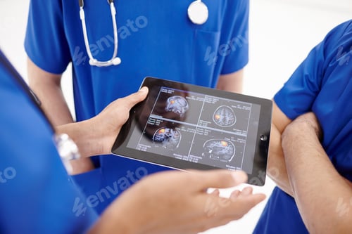 Preview: Doctors looking at scans on digital tablet