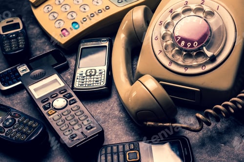 Preview: An old telephone with rotary dial, landline and obsoleted cellphone on a grunge background.