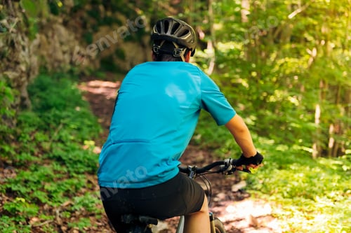 Preview: rear view of a cyclist riding his mountain bike