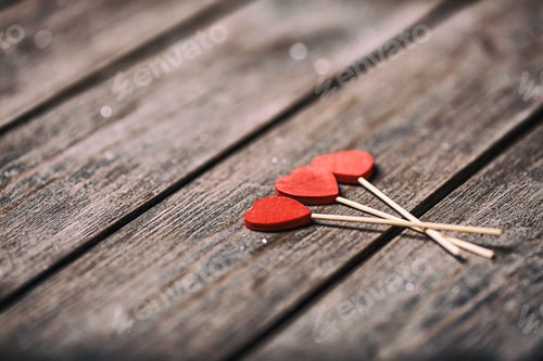 Preview: Three red hearts shape on stick over wooden background. Valentine concept. selective focus.
