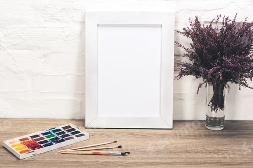Preview: close up view of photo frame, lavender flowers in vase and drawing equipment on wooden tabletop