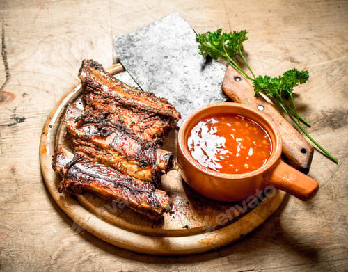 Preview: Barbecued ribs with tomato sauce and a carving hatchet.