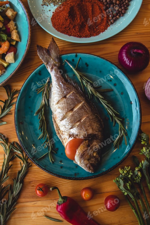 Preview: Fresh fish dorado. Dorado and ingredients for cooking on a table.