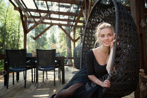 Woman in Black Dress Posing in Hanging Chair