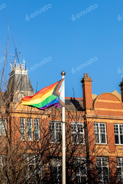 Preview: Vibrant rainbow lgbt flag billowing in the wind atop a majestic building in Manchester gay village