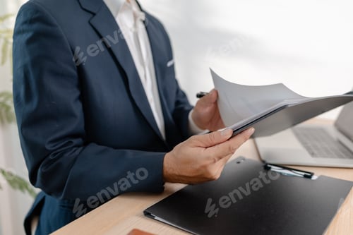 Preview: A businessman in a suit analyzing financial charts and performance reports in a bright modern office