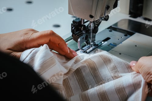 Preview: Closeup shot of seamstress hands working on sewing machine