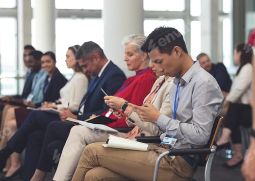 Preview: Side view of diverse business people attending a business seminar in modern office building