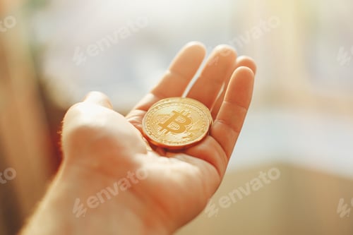 Preview: hand holding shiny golden bitcoins, gold money